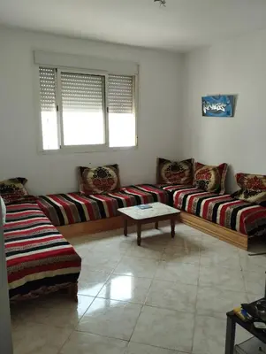 a living room with two couches and a table at résidence les perles de Bouznika in Bouznika