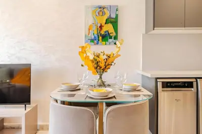 a kitchen with a table with a vase of yellow flowers at Studio Cosy, corniche à 2 min , Parking , Netflix in Casablanca