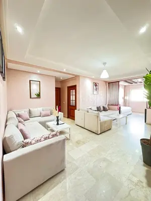 a living room with two white couches and tables at SUITOUISS - Agdal 2 - Appartements à 2 minutes de la gare de train TGV Rabat in Rabat