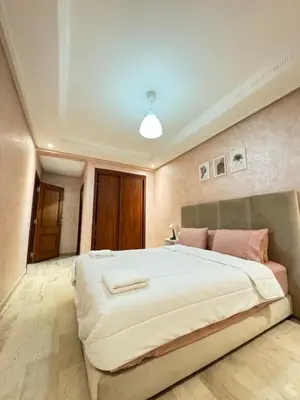 a large bedroom with a large bed with pink pillows at SUITOUISS - Agdal 2 - Appartements à 2 minutes de la gare de train TGV Rabat in Rabat