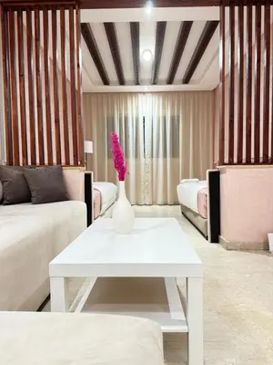 a living room with a white vase with flowers on a table at SUITOUISS - Agdal 2 - Appartements à 2 minutes de la gare de train TGV Rabat in Rabat