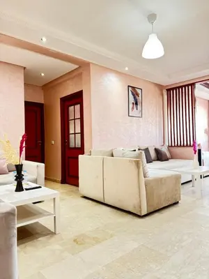 a living room with a couch and a table at SUITOUISS - Agdal 2 - Appartements à 2 minutes de la gare de train TGV Rabat in Rabat