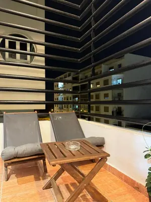 a table and two chairs and a table on a balcony at SUITOUISS - Agdal 2 - Appartements à 2 minutes de la gare de train TGV Rabat in Rabat