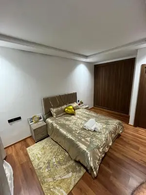 a bedroom with a bed with a gold bedspread at Beautiful Apartment with Seaside Pool in Mansouria