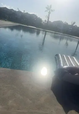 a swimming pool with a bench in front of it at Beautiful Apartment with Seaside Pool in Mansouria