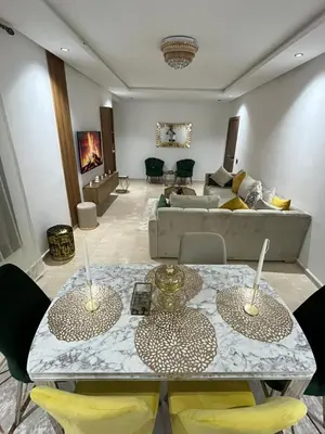 a living room with two tables and a couch at Beautiful Apartment with Seaside Pool in Mansouria