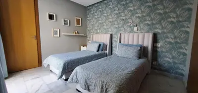 two beds in a room with blue and white wallpaper at Luxurious apartment casablanca in Casablanca