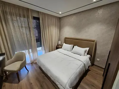 a bedroom with a bed and a chair and a window at Studio Seven Sky 1 - Close to CFC in Casablanca