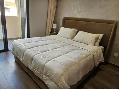 a large bed with white sheets and pillows at Studio Seven Sky 1 - Close to CFC in Casablanca