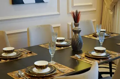 a dining room table with plates and glasses and a vase at Charming 2 Bedroom Casavoyageur in Casablanca