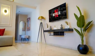 a living room with a television on a wall at Charming 2 Bedroom Casavoyageur in Casablanca