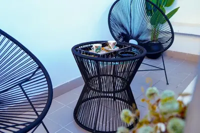 a black chair and a table with cups and a plant at Charming 2 Bedroom Casavoyageur in Casablanca