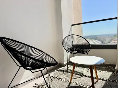 two black chairs and a table on a balcony at Appartement Miramar vue panoramique Mohammedia in Mohammedia