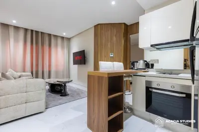 a kitchen and living room with a couch and a table at Acacia Studio 10 in Casablanca