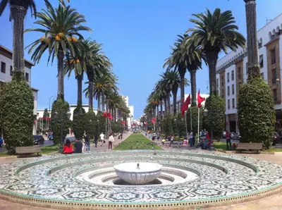 a fountain in the middle of a street with palm trees at Maison 2pc plain-pied -centre in Rabat