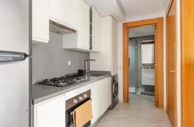 a kitchen with white cabinets and a stove top oven at Sunshine sea view studio in Casablanca