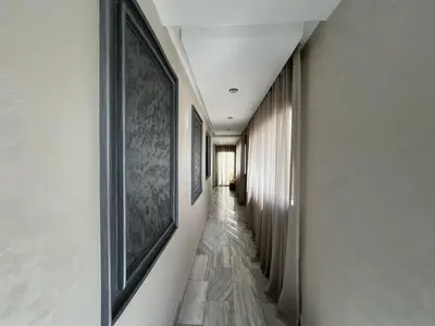 a hallway with paintings on the walls and a long corridor at Appartement luxueux au bord du mer in Casablanca