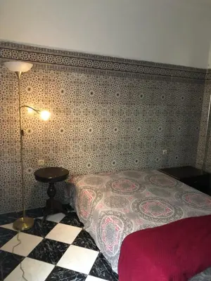 a bedroom with a bed and a tiled wall at Maison de la paix in Casablanca