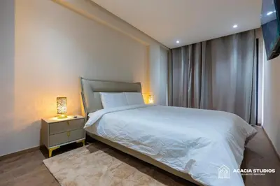 a bedroom with a bed and a night stand with a lamp at Acacia Studio 03 in Casablanca
