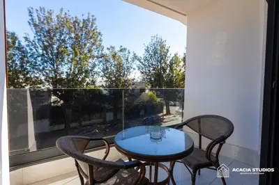 a glass table and chairs on a balcony with a window at Acacia Studio 03 in Casablanca