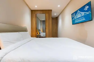 a bedroom with a white bed and a tv on the wall at Acacia Studio 06 in Casablanca