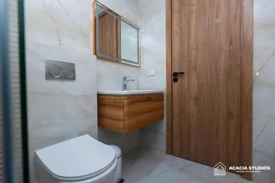 a bathroom with a toilet and a sink and a wooden door at Acacia Studio 07 in Casablanca