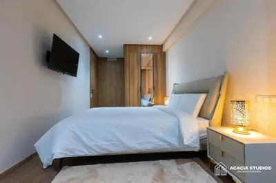a bedroom with a bed and a tv on a wall at Acacia Studio 08 in Casablanca