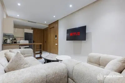 a living room with two couches and a tv on a wall at Acacia Studio 08 in Casablanca