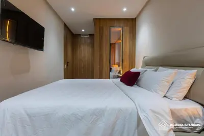 a bedroom with a white bed with a flat screen tv at Acacia Studio 09 in Casablanca