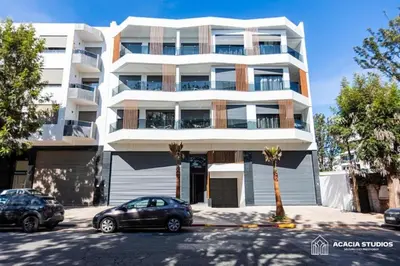 a building with two cars parked in front of it at Acacia Studio 09 in Casablanca