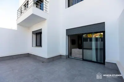 a white house with a large glass door at Acacia Studio 11 in Casablanca