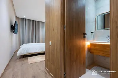 a bathroom with a wooden door leading to a bedroom at Acacia Studio 11 in Casablanca