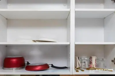 a white cabinet with a red pot and pans at Acacia Studio 12 in Casablanca