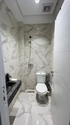 a white bathroom with a toilet and a sink at home garden in Casablanca