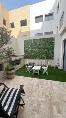 a patio with two chairs and a table in front of a building at home garden in Casablanca