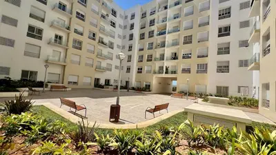 a large apartment building with benches and a courtyard at N28 3 Bedrooms & Private Gym just walking to Stade Moulay Abdellah in Rabat