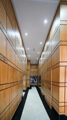 a hallway with wood paneled walls and a white aisle at Charmant appartement joyau du parc 200m plage in Mohammedia
