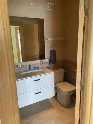 a bathroom with a sink and a toilet and a mirror at À LOUER APPARTEMENT à Casabay in Sidi Rahal
