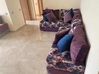 a couch with pillows on it in a living room at À LOUER APPARTEMENT à Casabay in Sidi Rahal