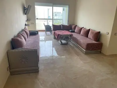 a living room with a couch and a table at À LOUER APPARTEMENT à Casabay in Sidi Rahal