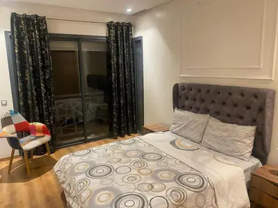 a bedroom with a bed and a chair and a window at Downtown delight studio in Casablanca