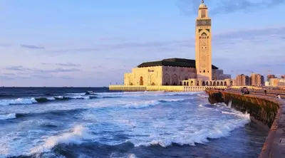 a building with a clock tower next to the ocean at Downtown delight studio in Casablanca