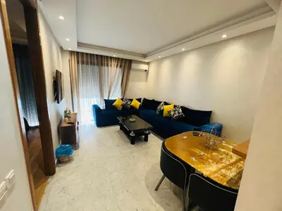 a living room with a blue couch and a table at Ataraxia in Casablanca