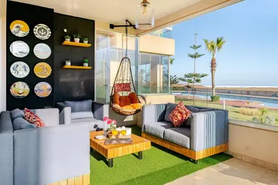a living room with two couches and a table at Appartement de Luxe - Piscine et Accès à la Plage in Bouznika