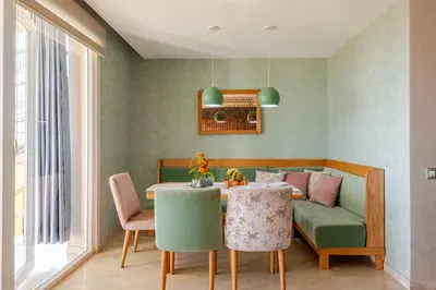 a dining room with a table and a couch at Appartement de Luxe - Piscine et Accès à la Plage in Bouznika