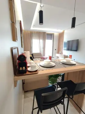 a kitchen and dining room with a table and chairs at Residence La Reine II 24H Reception Cosy & Central Apartment 1 Minute Near To MOHAMMED V SPORTS COMPLEX 5 Min By Car To Ain Diab Corniche With Optical Fiber Wifi Casablanca in Casablanca