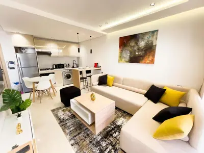 a living room with a white couch and yellow pillows at Residence La Reine II 24H Reception Cosy & Central Apartment 1 Minute Near To MOHAMMED V SPORTS COMPLEX 5 Min By Car To Ain Diab Corniche With Optical Fiber Wifi Casablanca in Casablanca