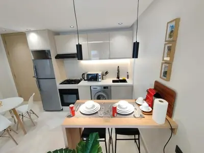 a small kitchen with a table with plates on it at Residence La Reine II 24H Reception Cosy & Central Apartment 1 Minute Near To MOHAMMED V SPORTS COMPLEX 5 Min By Car To Ain Diab Corniche With Optical Fiber Wifi Casablanca in Casablanca