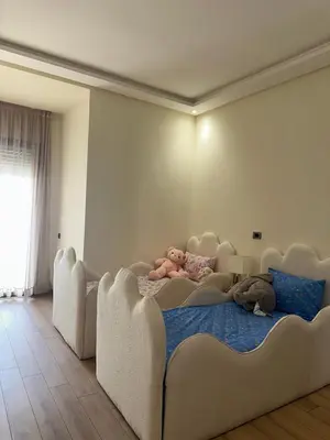 a baby laying on a bed in a room at Appartement Les Crêtes in Casablanca