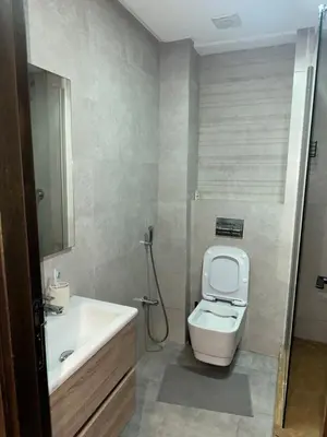 a bathroom with a white toilet and a sink at Appartement Les Crêtes in Casablanca